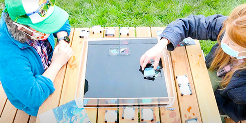 Two students playing a boardgame designed for the course: Nano Micro Macro