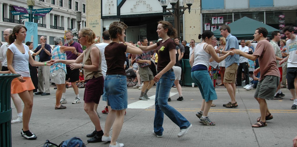 Adults dancing outside in a plaza. 