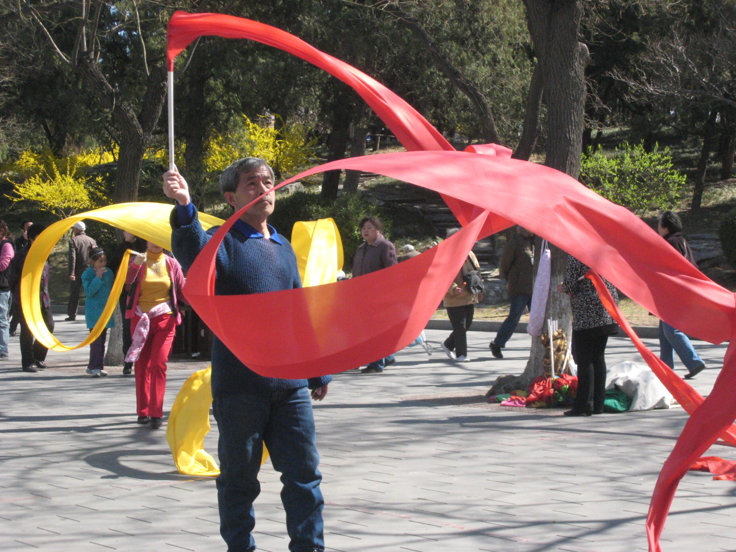 Man, twirls flag in outdoor activity.