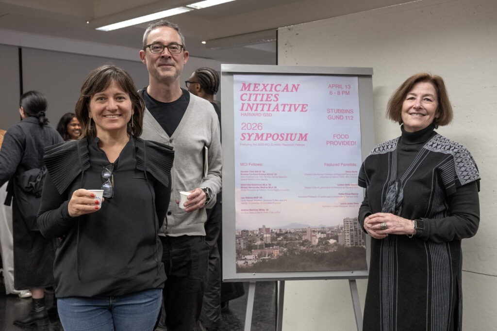 MCI Panelists standing and smiling in front of a Mexican Cities Initiative event poster
