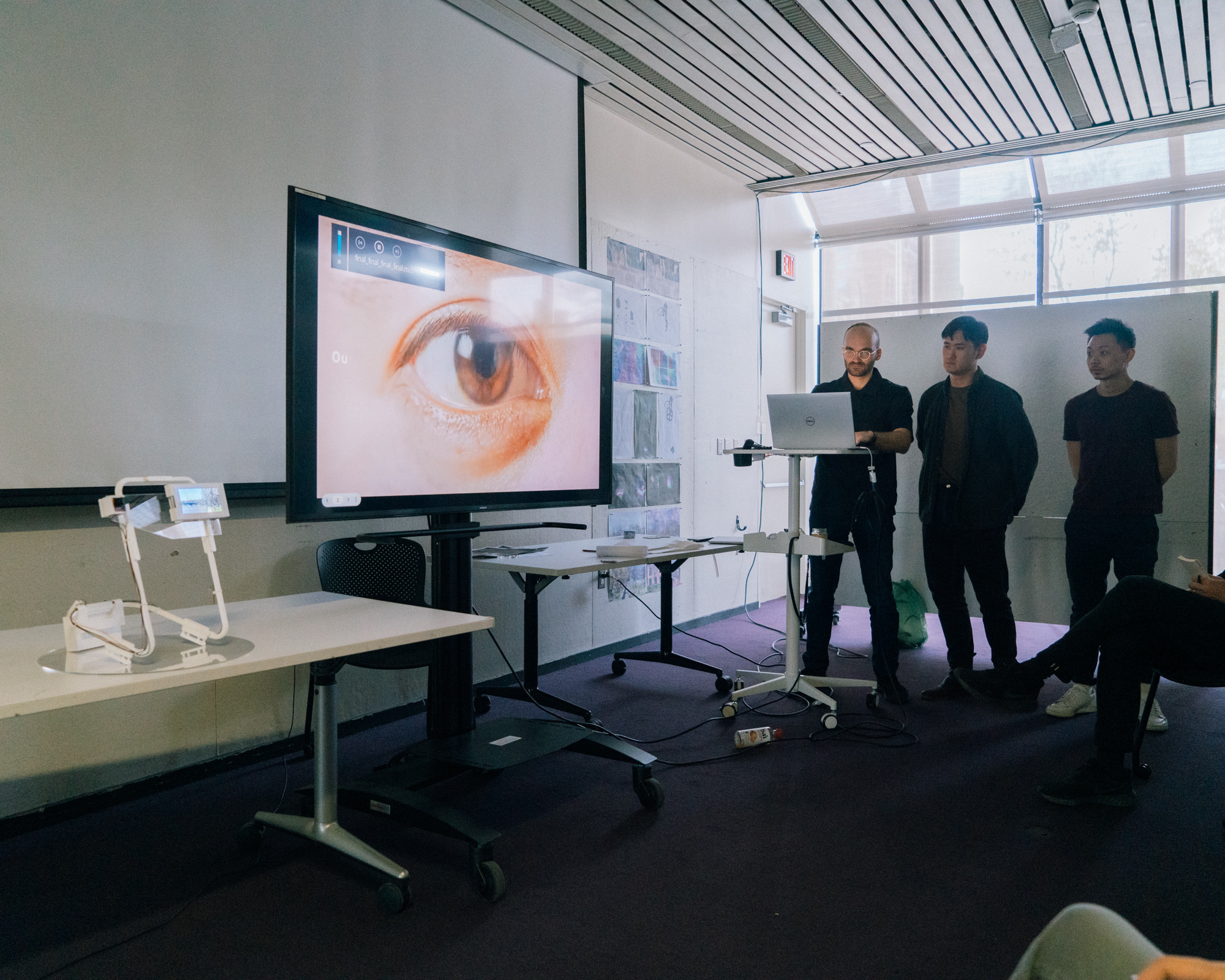 three students presenting in a class room