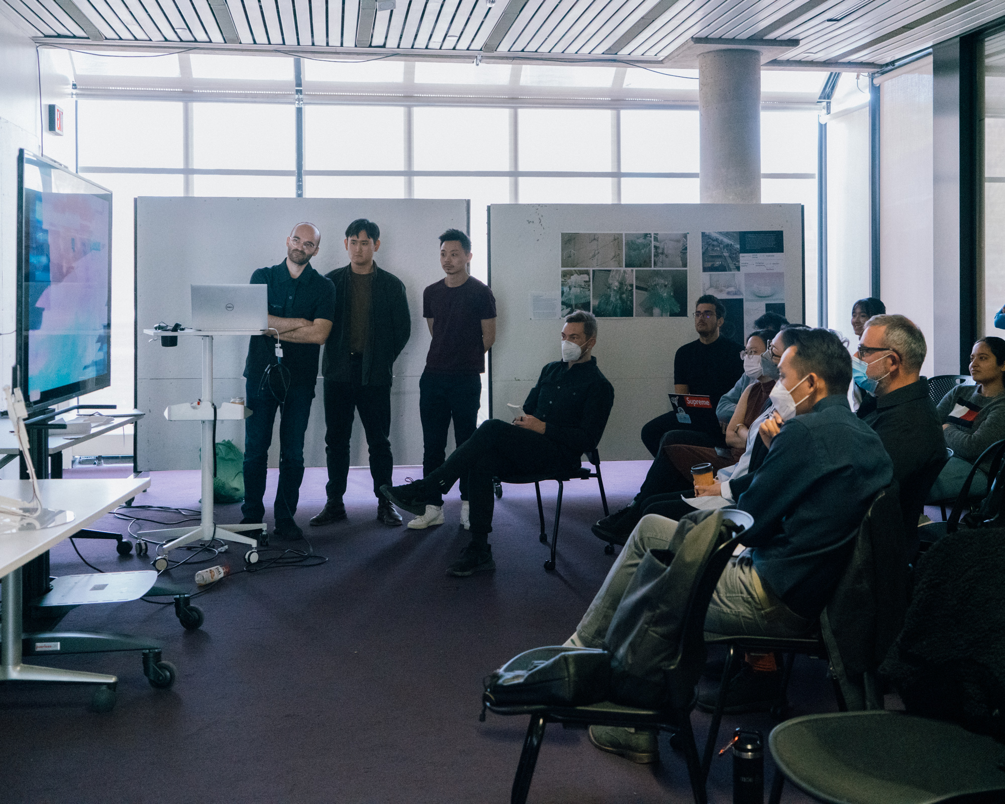 three students presenting in a class room in front of an audience